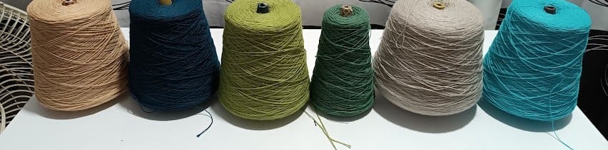 Conos de hilo en tonos camel, azul, oliva, verde, arena y turquesa.