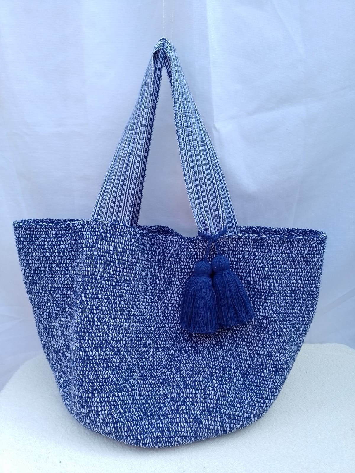 Totem Azul, bolso tejido a mano en crochet. Azul jaspeado, con borlas al tono.