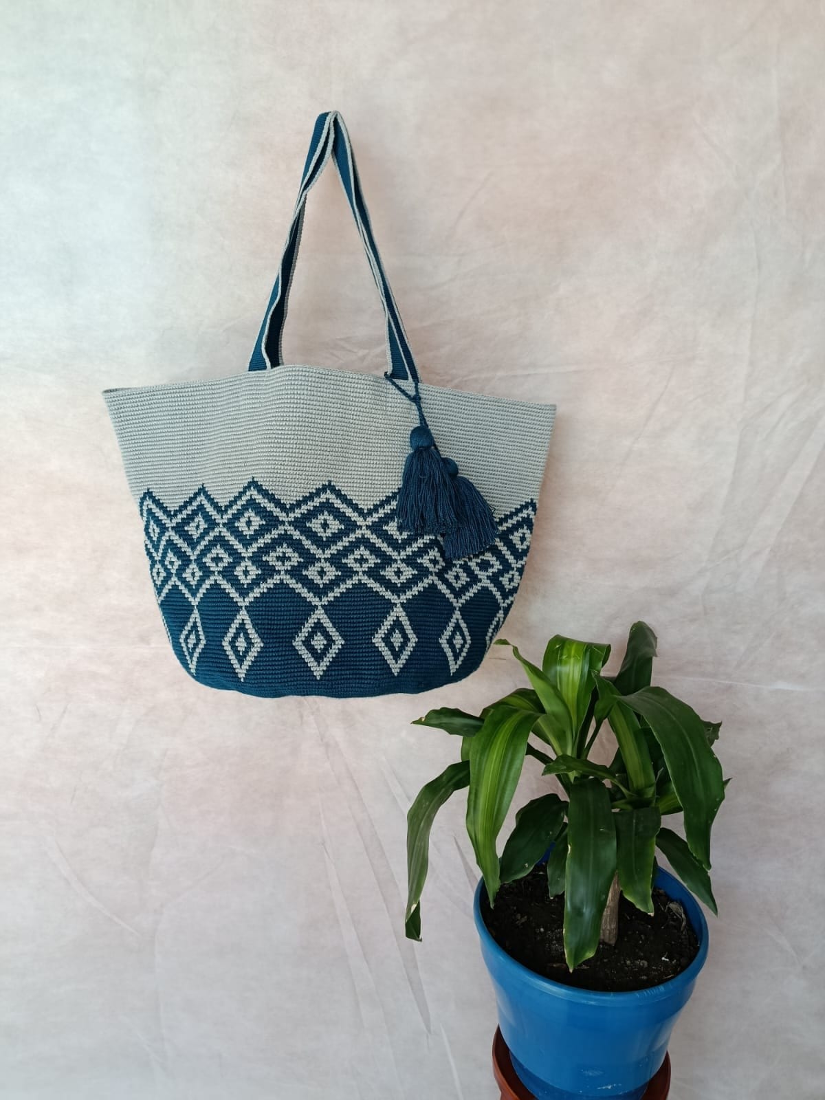Totem Celeste, bolso tejido a mano en crochet. Rombos en petróleo que suben en escalera sobre celeste.