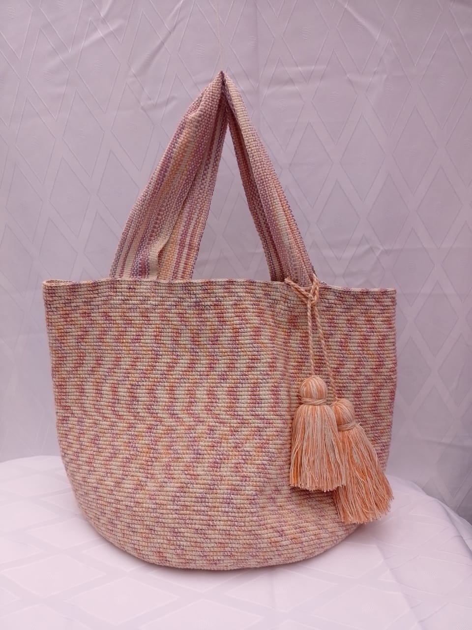 Totem Coral, bolso tejido a mano en crochet. Coral, durazno y lila en un zigzag suave.