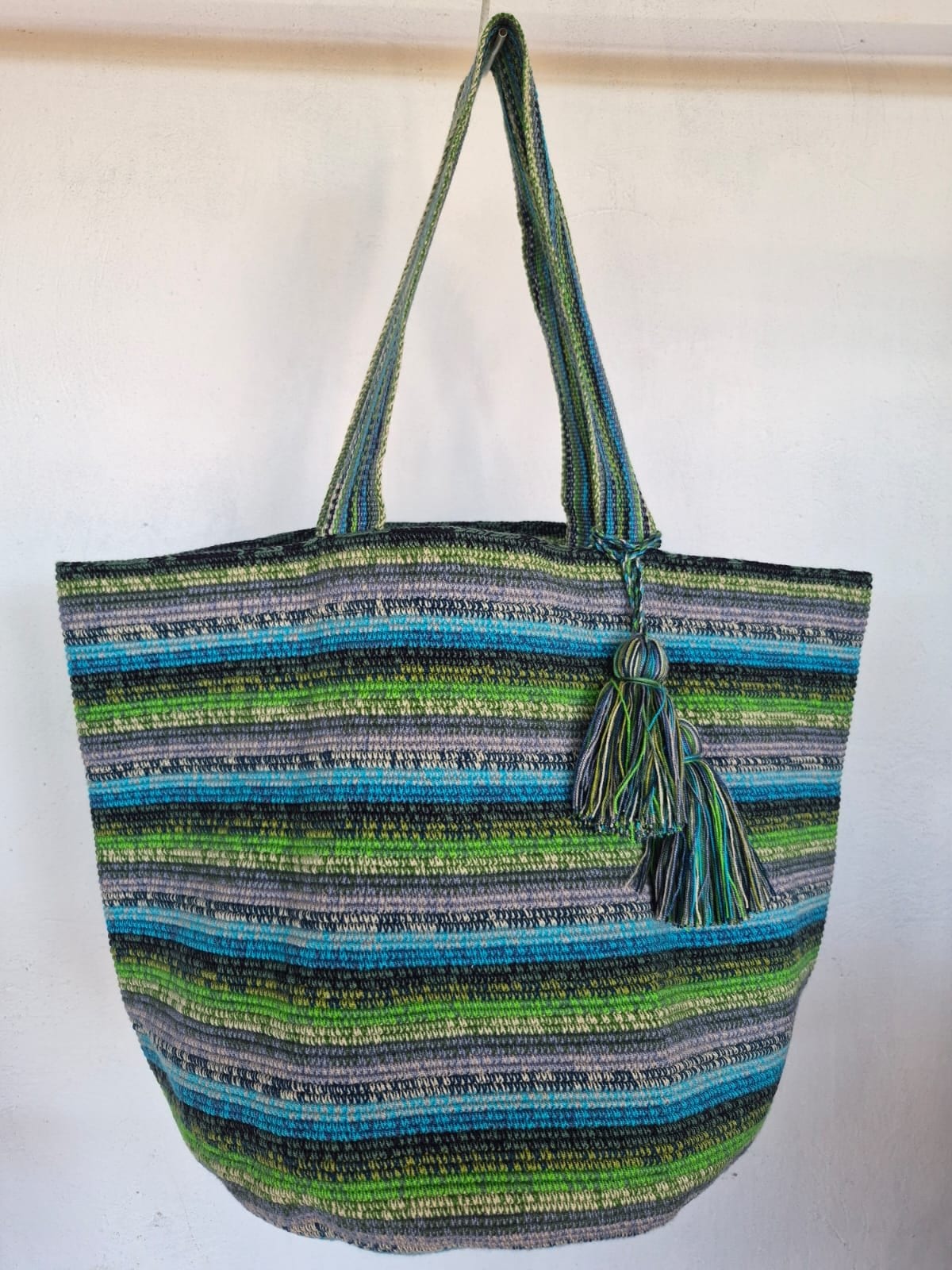 Totem Laguna, hand-crocheted bag. Marled bands of green, turquoise and grey, with two matching tassels.